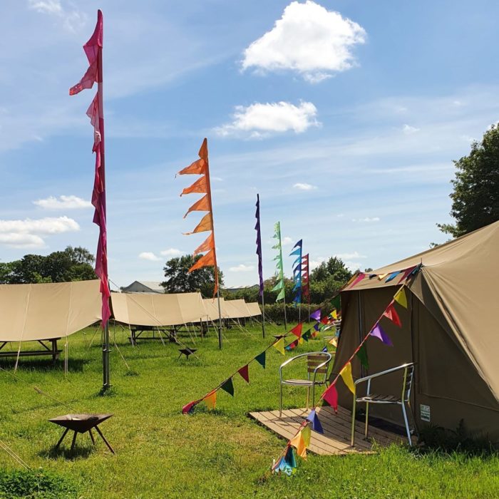 Canvas glamping tents and bright festival flags